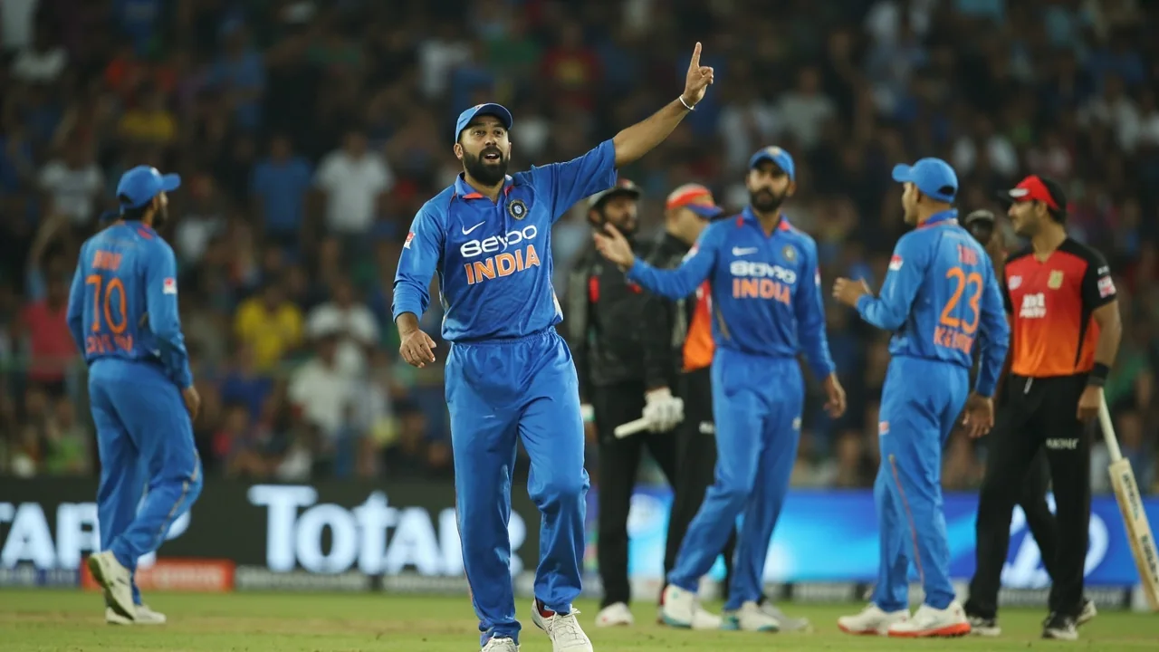 Wrist-spin bowler releasing the ball during an evening net session with team support staff watching from the background